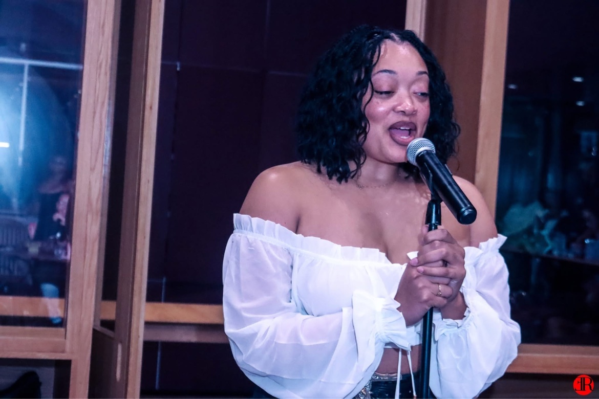 A singer in a white top performing on stage